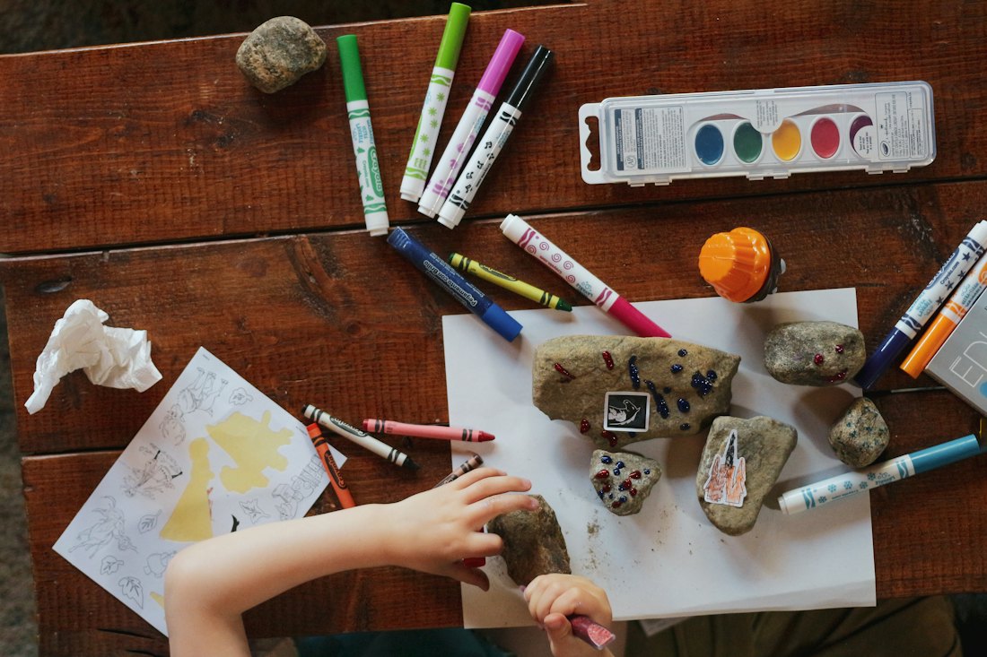 Child's hands painting at a wooden table